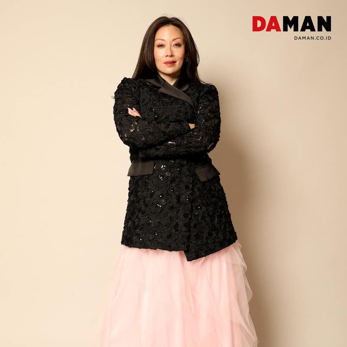 Fiona Rene wearing a black embellished jacket and pink tulle skirt with her arms crossed.