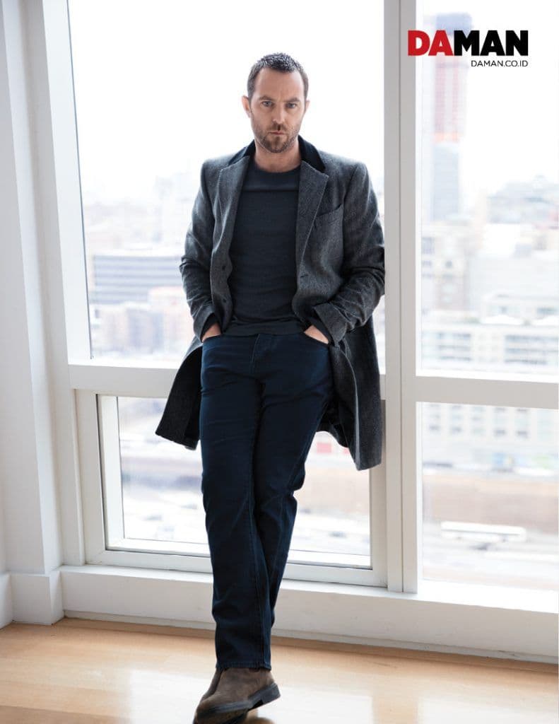 SULLIVAN STAPLETON of Blindspot NBC in T-shirt, coat and denim trousers by Burberry, boots by clarks