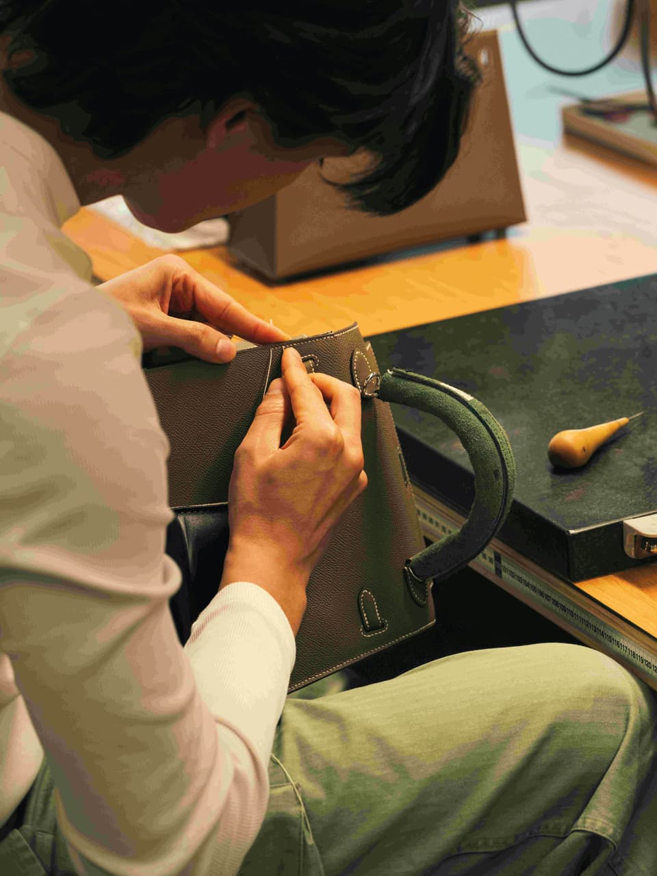 An artisan in the Loupes workshop crafting Hermès Kelly