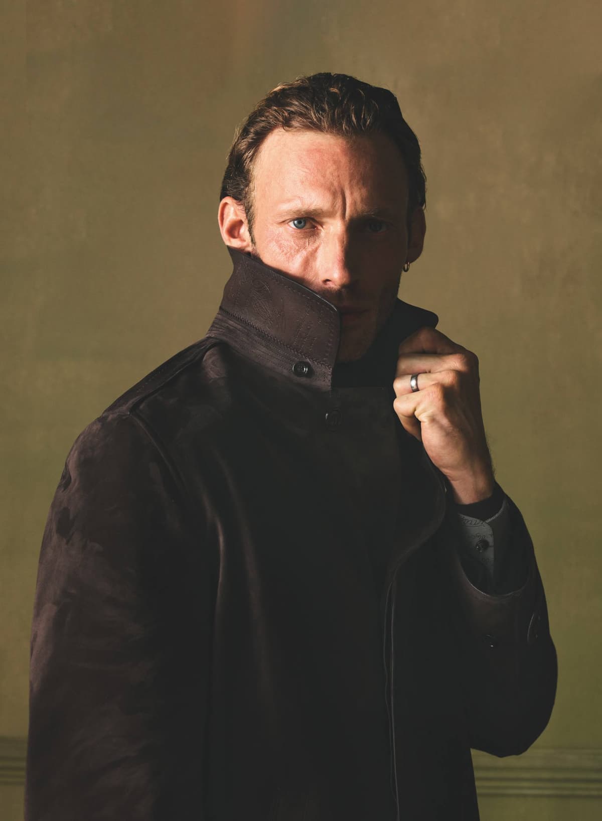 Close-up of a model raising the collar of a dark Berluti leather jacket, from Berluti Fall/Winter 2026 collection.